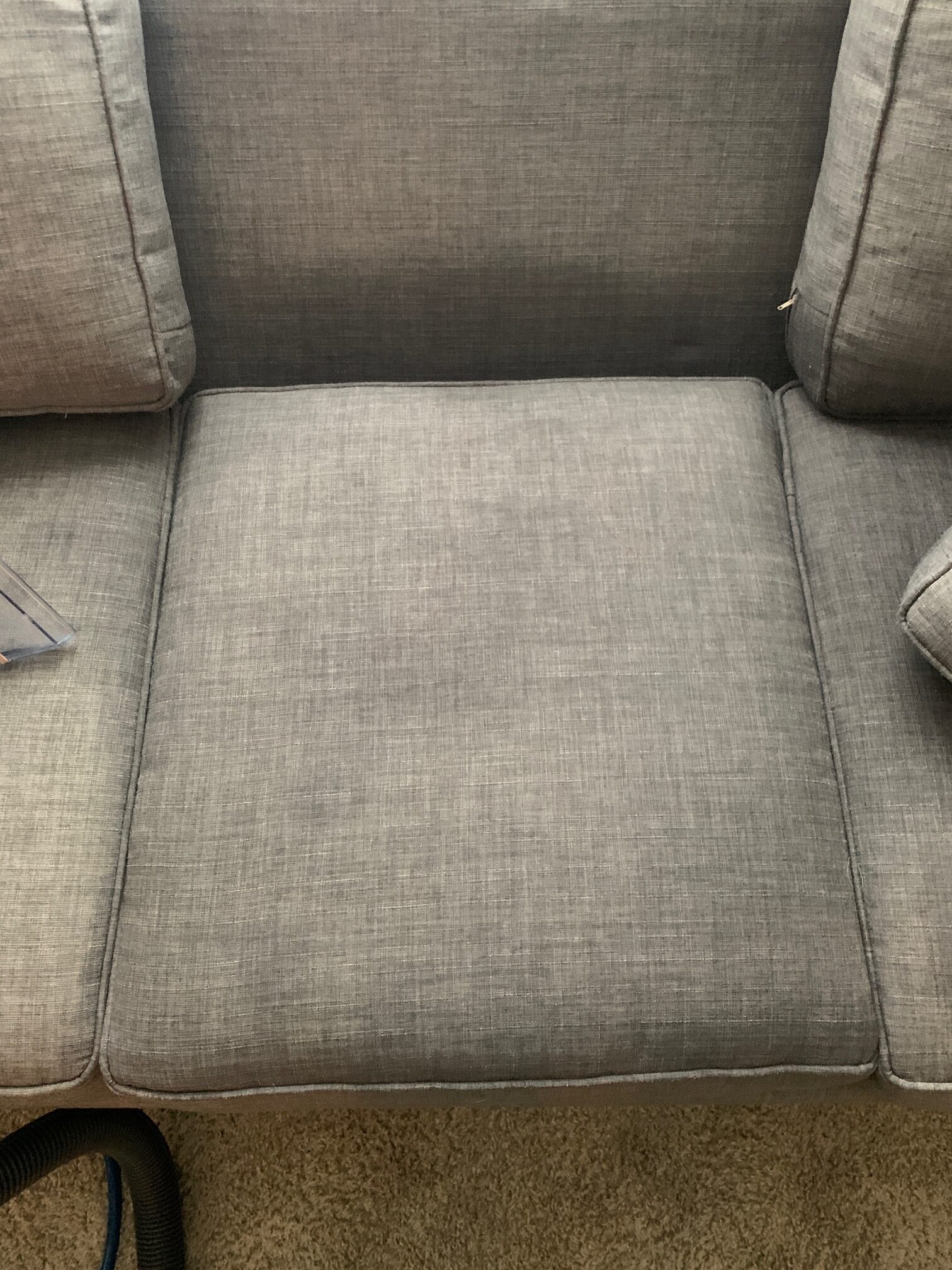 Upholstery cleaning service showing stained sofa fabric before treatment and noticeably cleaner results after professional care