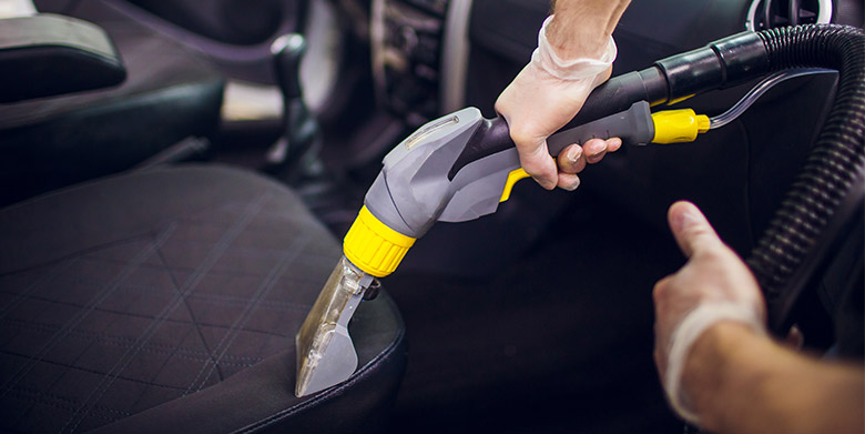 Professional cleaner performing deep car seat cleaning as part of a complete car interior cleaning service