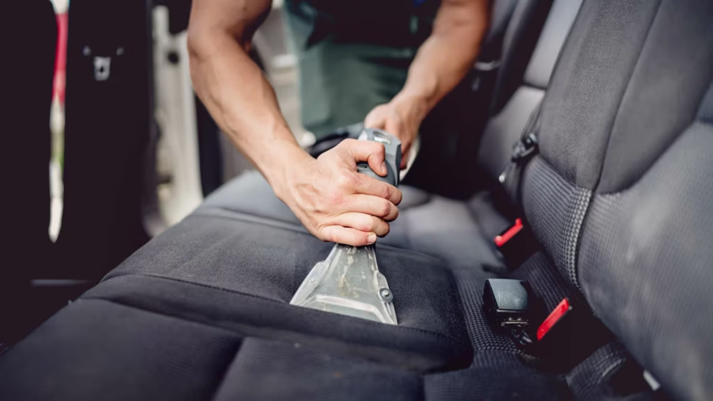 Professional vehicle interior cleaning in San Diego with a trained technician deep cleaning a car interior, seats, and surfaces for a fresh, like-new result